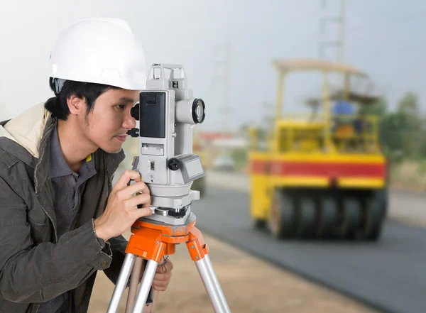 Engineer working with survey equipment theodolite with road unde