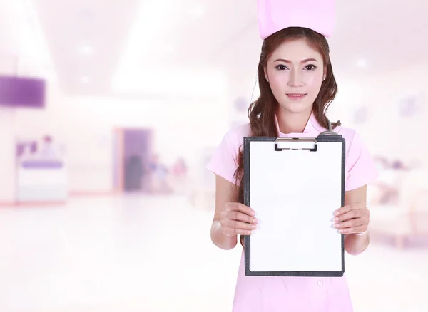 Female nurse show blank clipboard in hospital