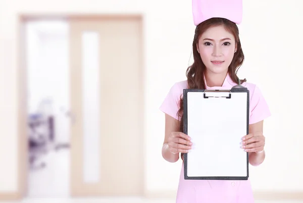 Female nurse show blank clipboard in hospital