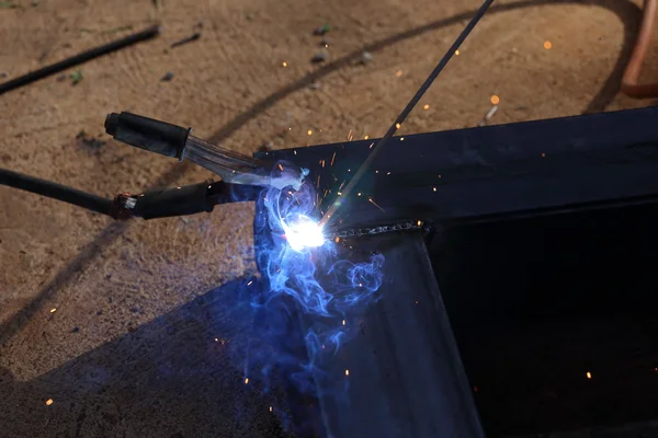 Hand of worker welding metal