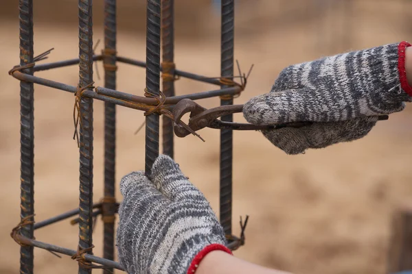 Construction worker hands working with pincers on fixin