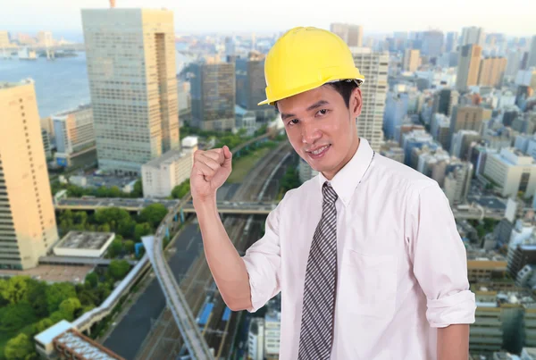 Happy engineer with arm raised, concept of successful, city back