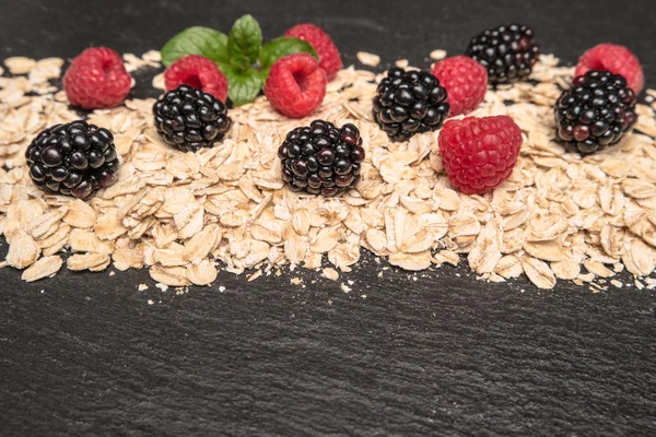 Healthy breakfast and berries on slate background, close-up