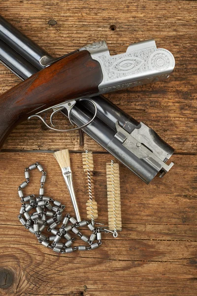 Hunting gun with cleaning kit on a wooden table