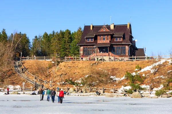 Morskie Oko Lake, POLAND - MARCH 14: Unidentified group of tourists are walking on the frozen Morskie Oko Lake, Poland on March 14, 2014.Tatra Mountains is very popular travel destination.