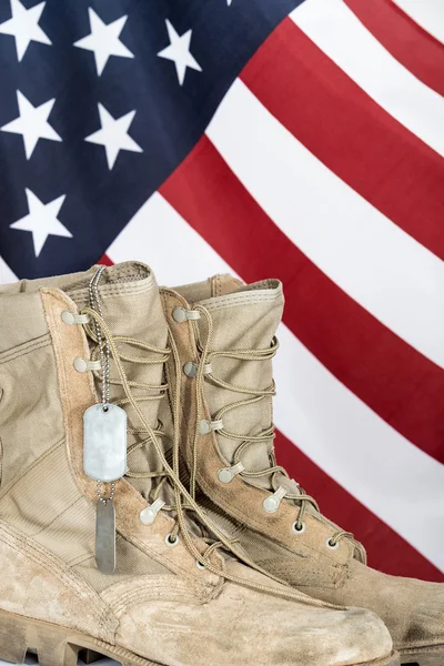 Old combat boots and dog tags with American flag