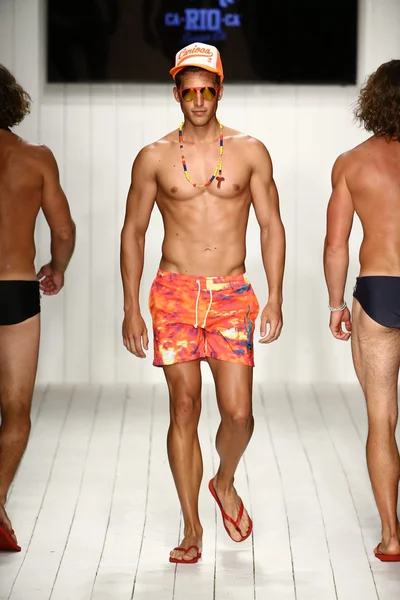 Models walks runway in designer swim apparel