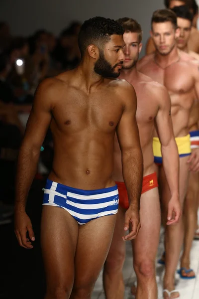 Models walks runway in designer swim apparel