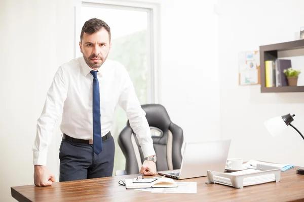 Businessman standing in front of his office desk