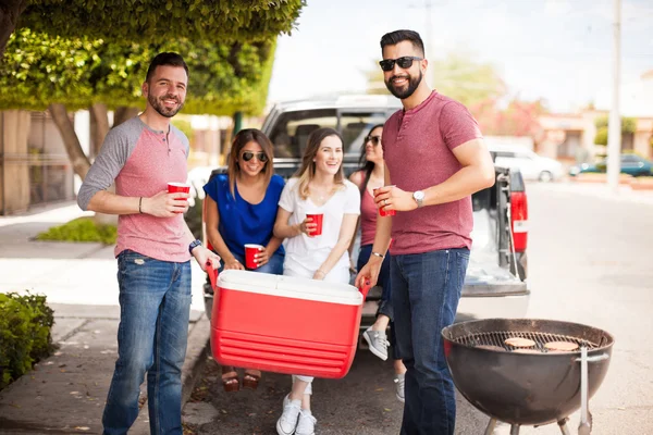Friends bringing drinks to a barbecue