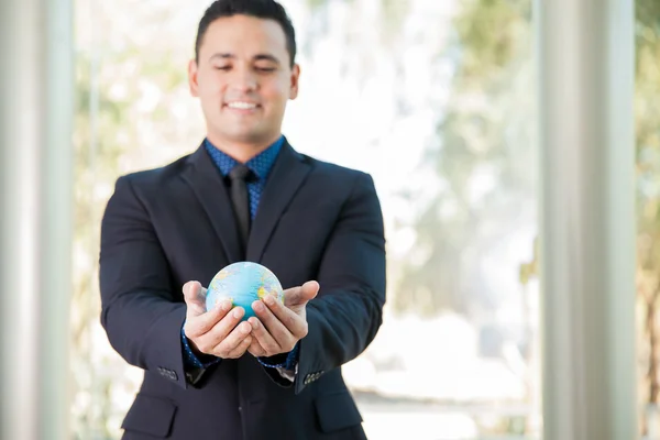 Businessman holding globe in hands