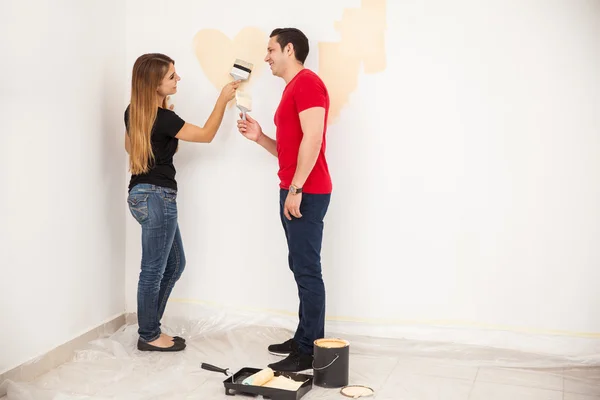 Young couple painting a room