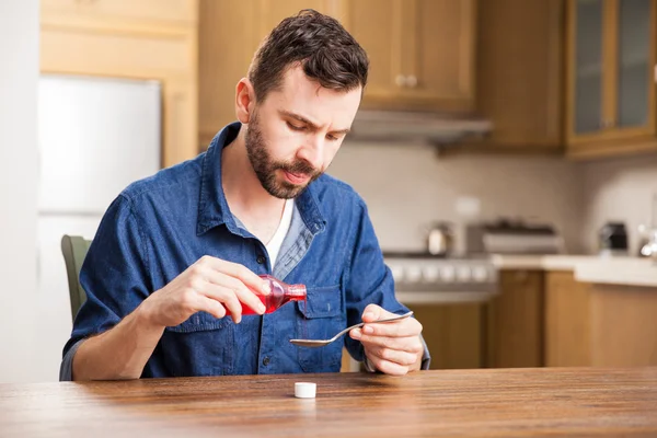 Man serving a spoonful of cough syrup