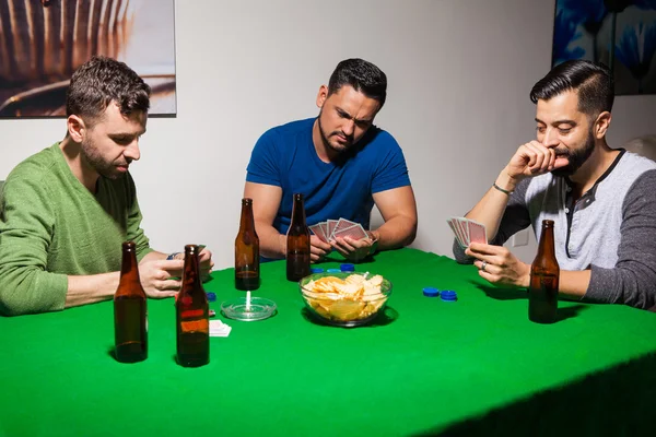 Friends drinking beer and playing cards