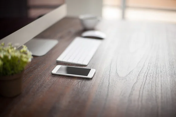 Smartphone and plant  on a wooden desk