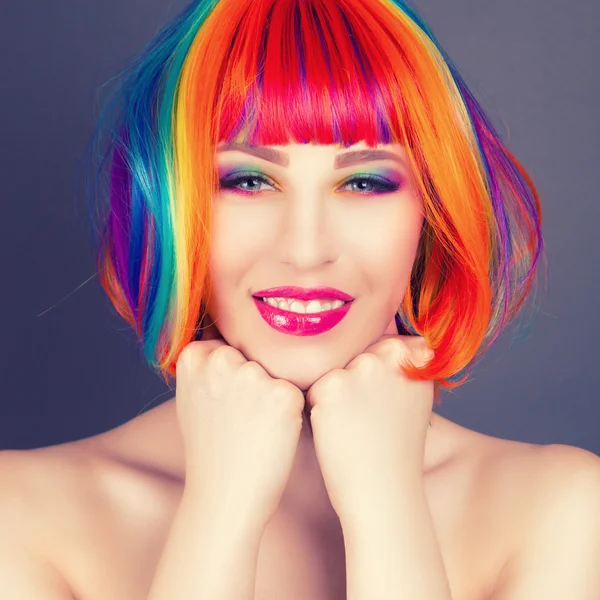 Beautiful woman wearing colorful wig and showing colorful nails