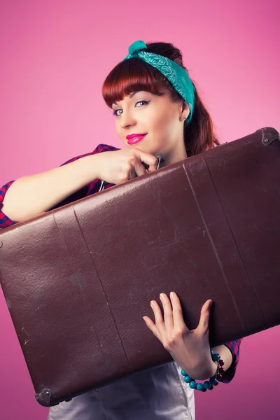 Pin-up girl posing with vintage suitcase