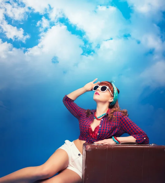 Pin-up girl posing with vintage suitcase