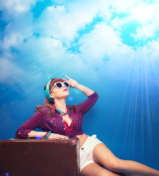 Pin-up girl posing with vintage suitcase