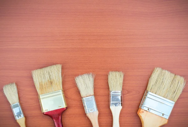 Paint brushes on a wooden background