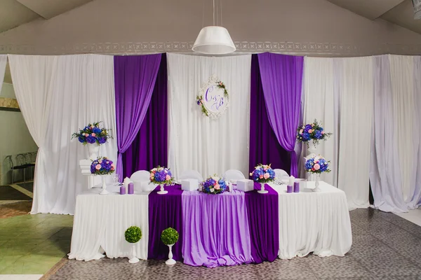 Head table for newlyweds at the wedding hall. Purple, violet tableware