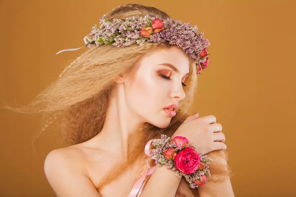 Young model with wreath of bright flowers on her head