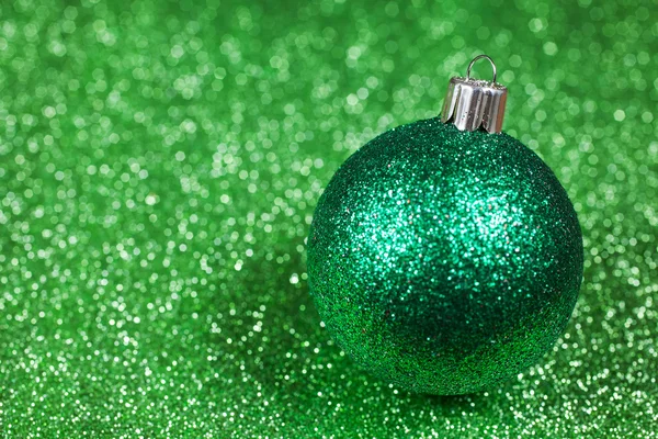 Christmas decorative green ball on glitter bokeh background