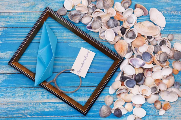 Sign Sea adventure and paper Boat with shells and photo frame