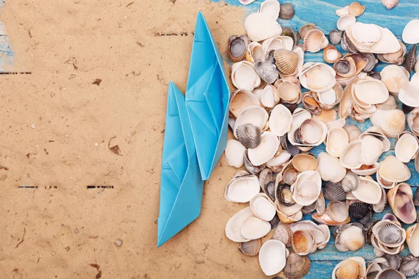 Paper Boat with shells and sand. Vocation and travel background