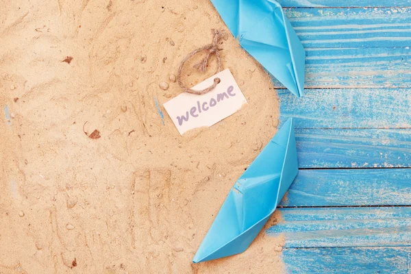 Paper Boat with shells and sand with sign - Welcome. Vocation and travel background