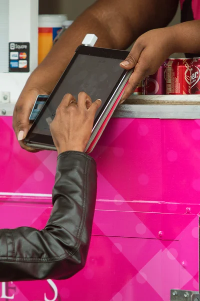Woman Signs Digital Tablet With Finger In Credit Card Transaction