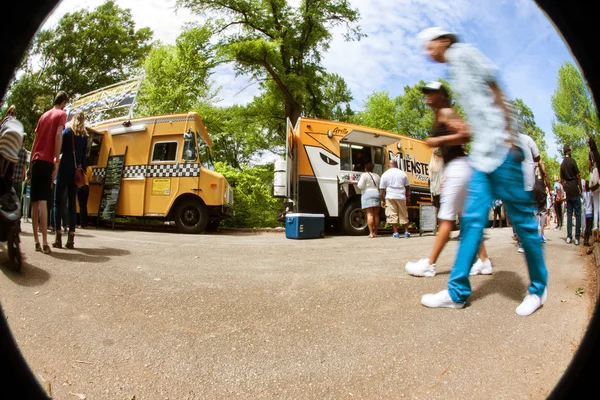 Motion Blur Fisheye Perspective Of People Walking By Food Trucks