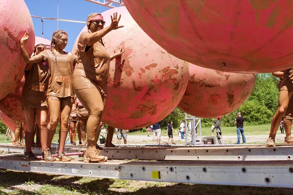 Muddy Women Dodge Rubber Balls At Dirty Girl Mud Run