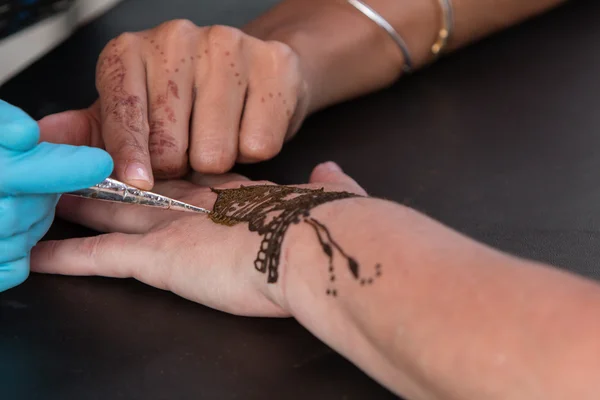 Woman Gets Temporary Henna Tattoo On Hand
