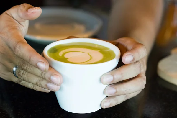 Serving freshly brewed hot milk green tea to you