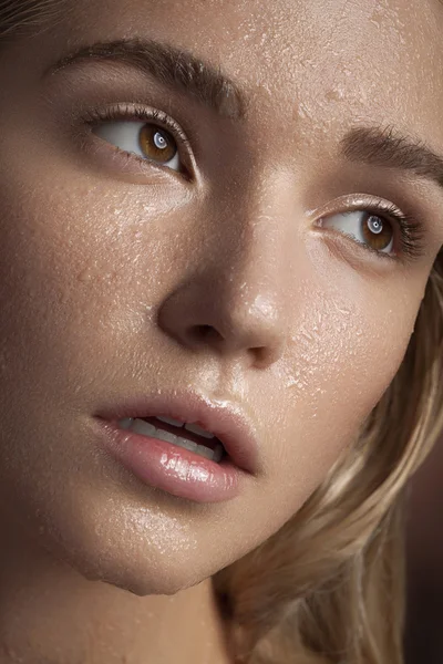 Gorgeous woman with perfect skin and water drops on face