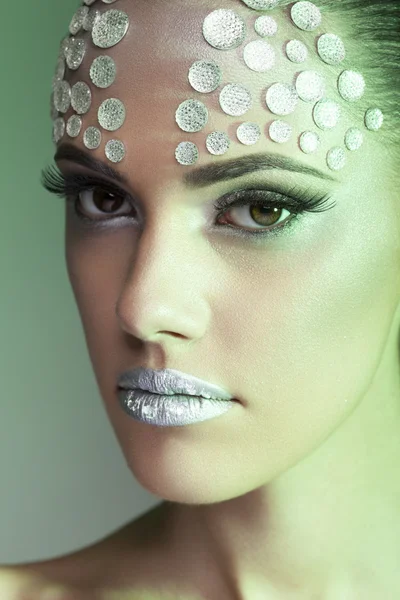 Make up and beauty. Woman with rhinesones on face. On stage make