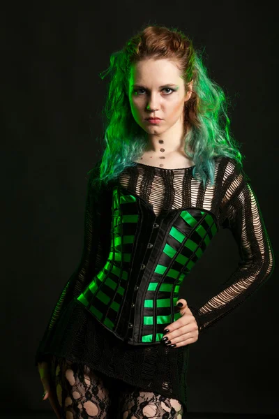 Alternative fashion model in stockings with green lights behind