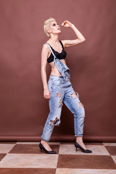 Woman in jeans and bra posing in fashion style