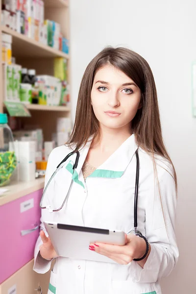 Nurse with digital tablet in hands inside pharmacy