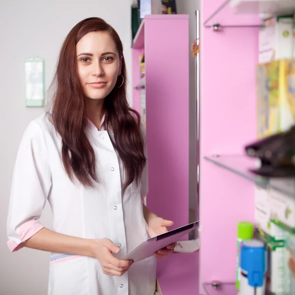 Doctor with digital tablet in hands in pharmacy