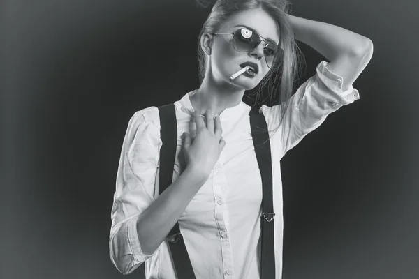 Woman with suspenders smoking sensual a cigarette