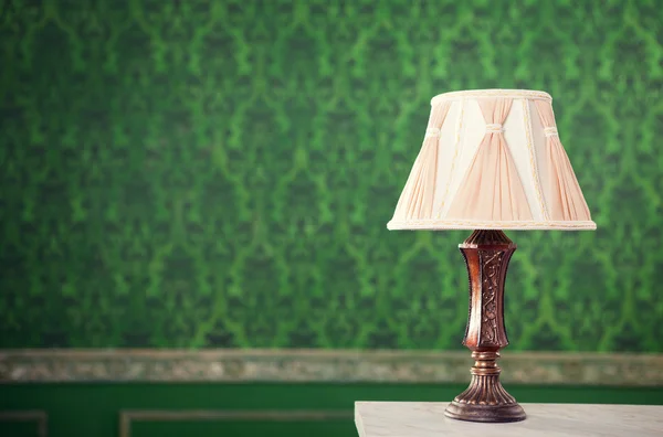 Vintage lamp on fireplace on retro pattern background