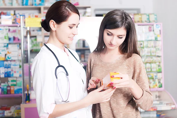 Client next to doctor looking at product inside a pharmacy