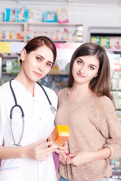Pharmacy worker showing product to client