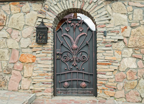 Forged metal gate in a stone fence