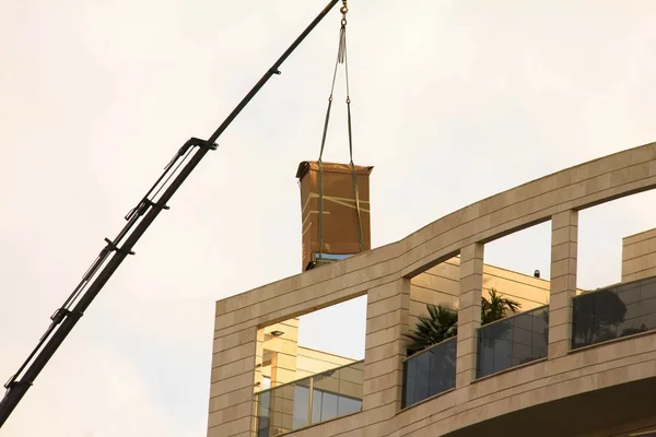 Delivery of the refrigerator in  original packaging to the penthouse via truck crane