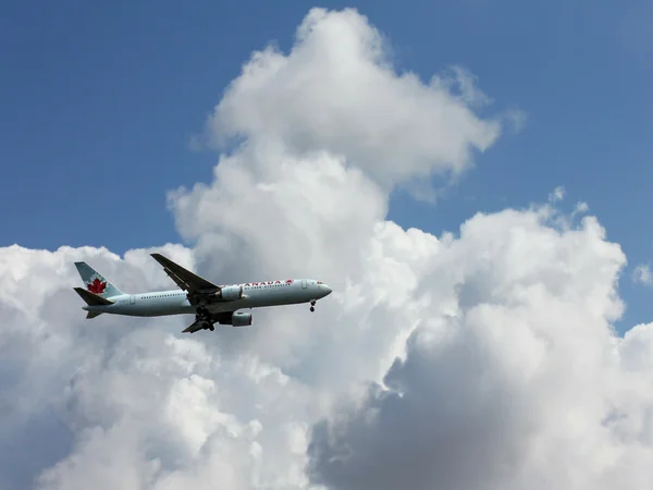 Air Canada plane is preparing to land at Ben Gurion Airport on a  white clouds and blue sky background