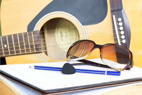 Close up guitar and pencil for create music select focus