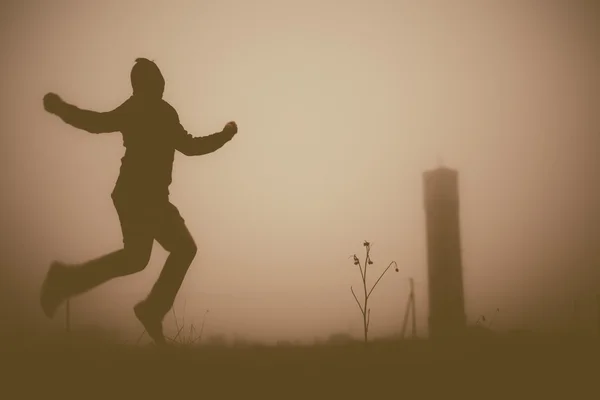 Silhouette of the jumping person in the evening.